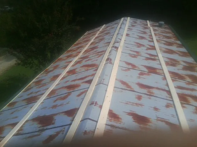 Rusted metal roof panels with new wood purlins before replacement — Storm Damage Roof Repair in Millbrook by Roofing Brothers