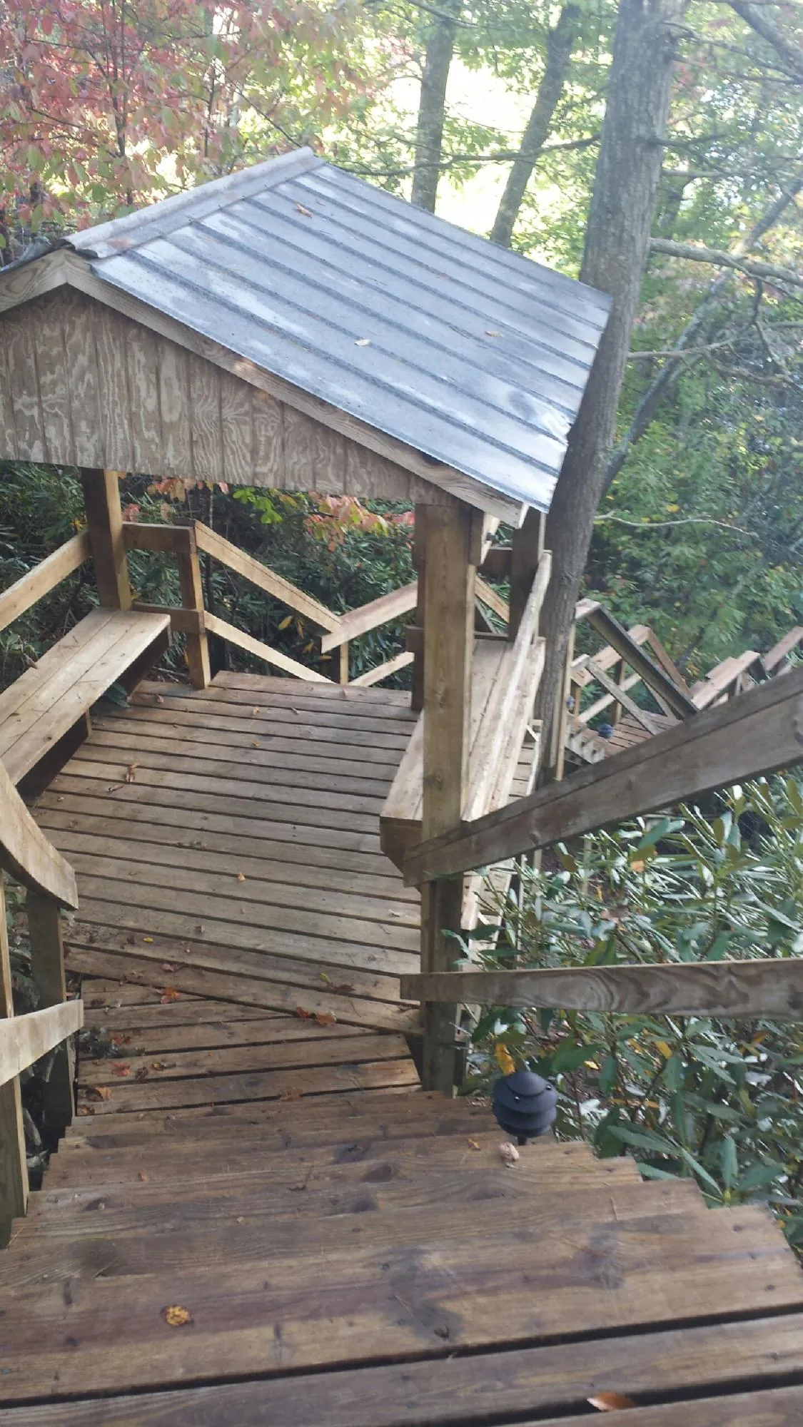 Metal roofed shelter over wooden steps on a wooded walkway — Skylight Repair & Installation work by our crew in Millbrook